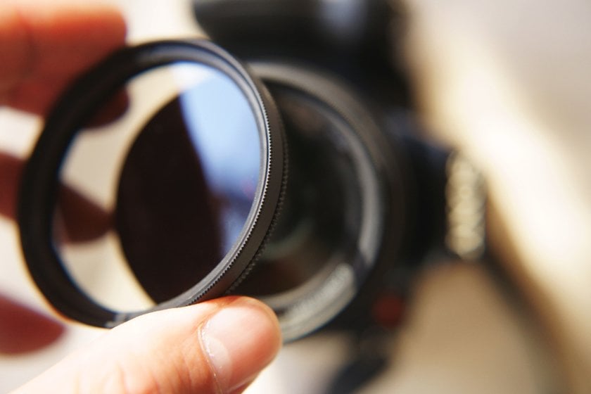 A photographer puts a filter on his camera | Skylum Blog