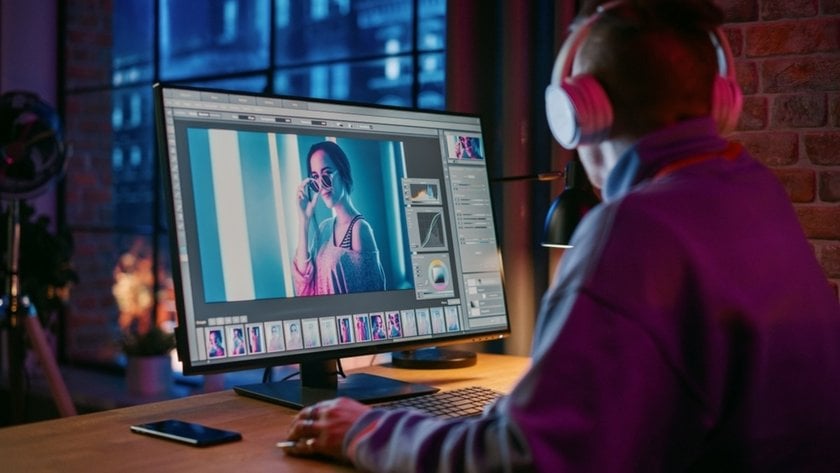 A photographer works on a computer using a photo editor | Skylum Blog