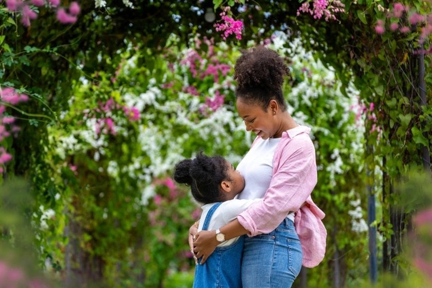 A mother and daughter hug in a park in spring | Skylum Blog