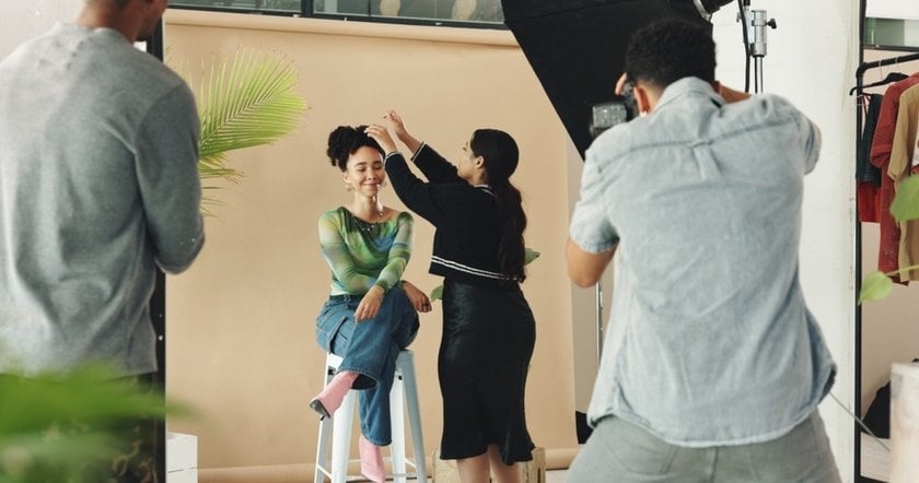 A makeup artist touches up a model's makeup in a photo studio | Skylum Blog