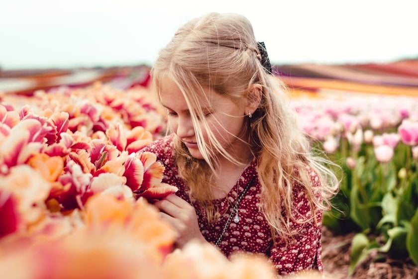 A girl smelling tulips in a tulip field | Skylum Blog