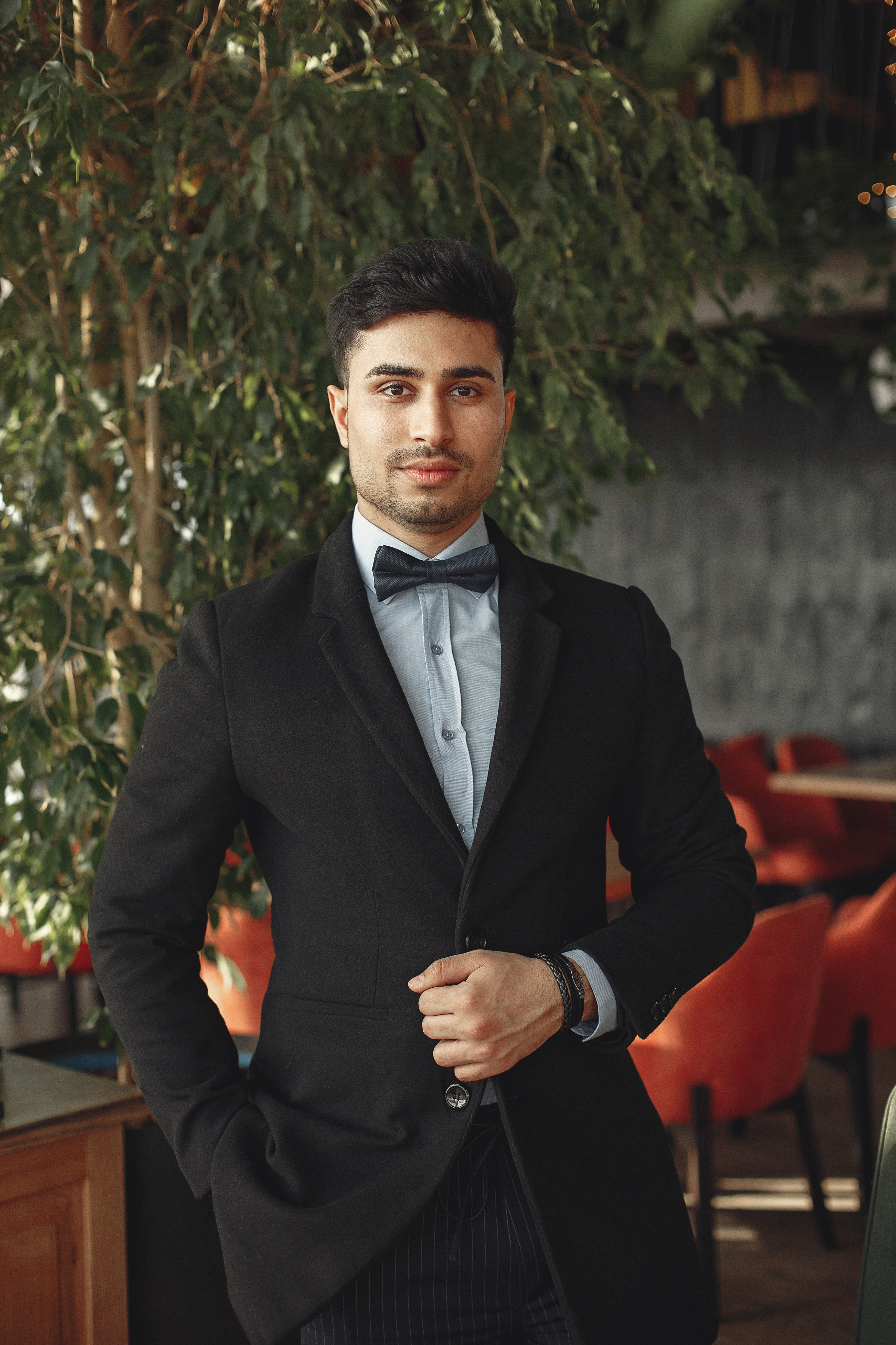 Young Fashion Man In Blue Suit Looking Down, Fixing Coat And Standing In A  Fashion Pose On Grey Background Stock Photo, Picture and Royalty Free  Image. Image 133301638.