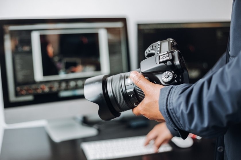 Photographer with camera works with editor | Skylum Blog