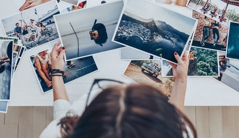 Girl Looking at Printed Photos | Skylum Blog