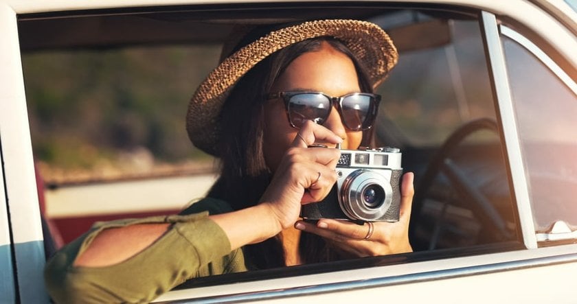 Photo of a Girl in Sunglasses Taking a Picture of the Sun | Skylum Blog