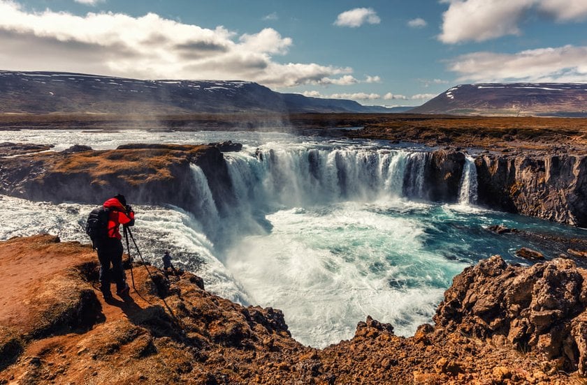 Man Taking a Photo of a Waterfall in Iceland | Skylum Blog