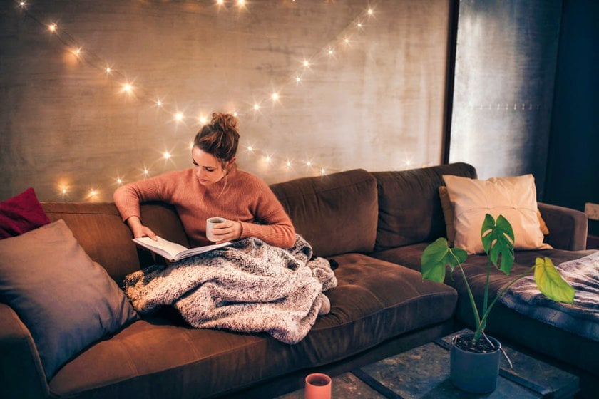 Girl Reading a Book on the Sofa in a Cozy Living Room | Skylum Blog