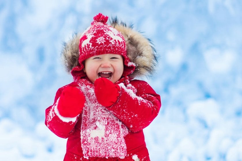 Cheerful Child in Winter Outfit Playing with Snow | Skylum Blog