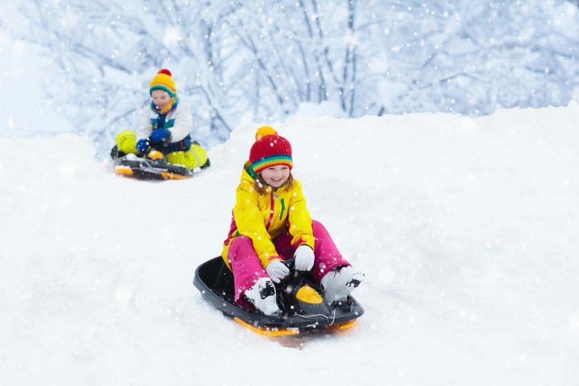 Children in Colorful Jackets Sledding | Skylum Blog