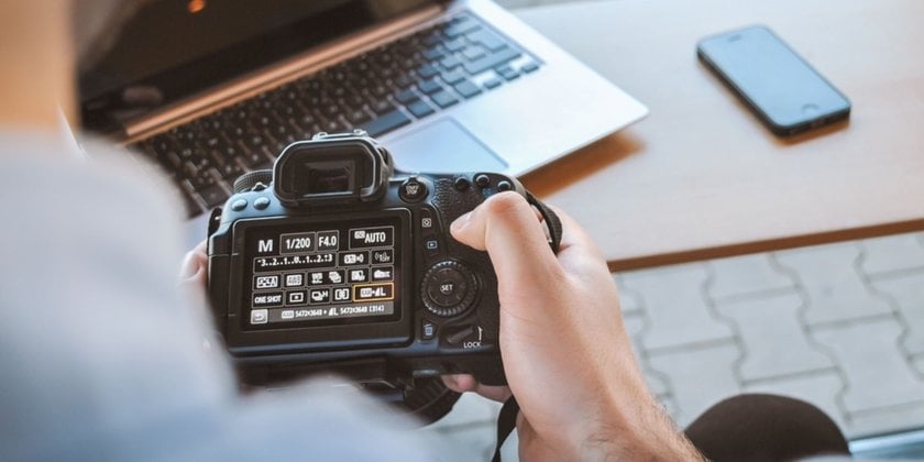 A photographer adjusts his camera | Skylum Blog