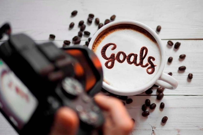 Photographer Capturing a Photo of the Word “Goals” on a Cappuccino | Skylum Blog