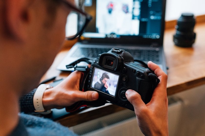 A photographer looks at a photo on his camera | Skylum Blog