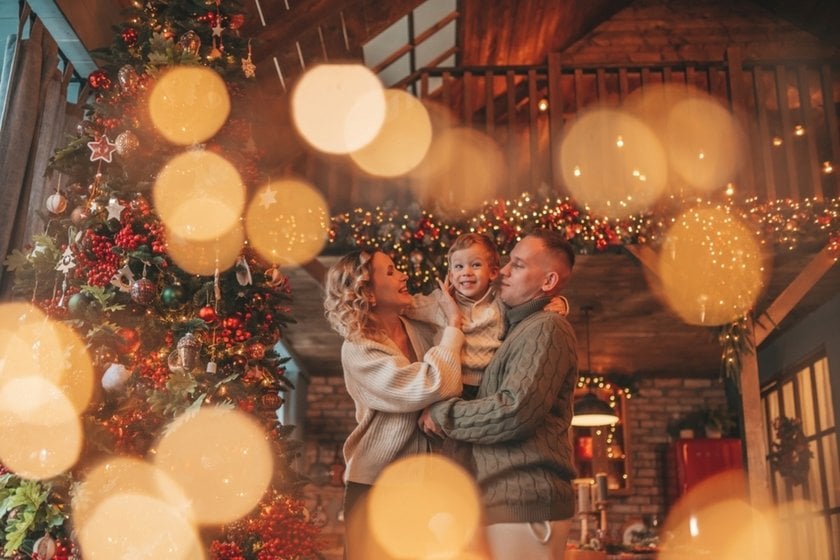 A family photo by the Christmas tree with a bokeh effect | Skylum Blog