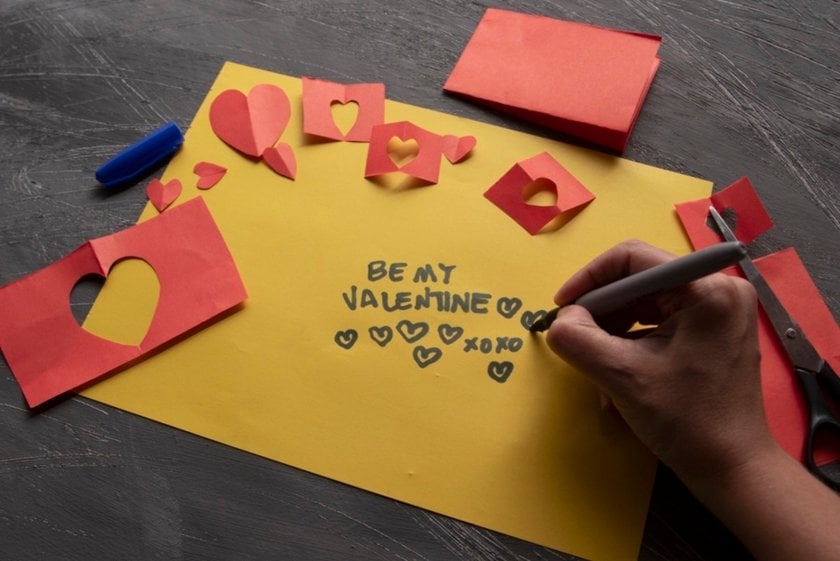 Hands writing a message on a yellow card with hearts | Skylum Blog