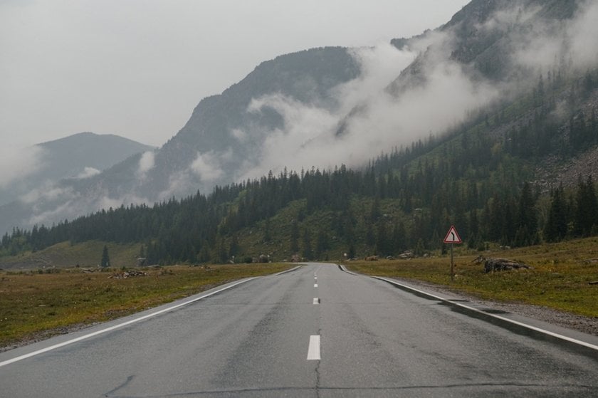 Photo of a mountain road in foggy cloudy weather | Skylum Blog