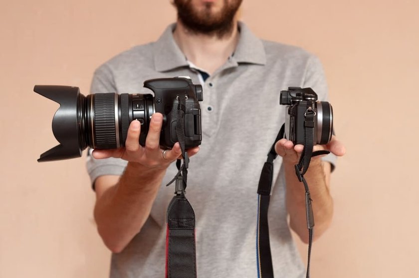 Man Holding an SLR and a DSLR Camera | Skylum Blog